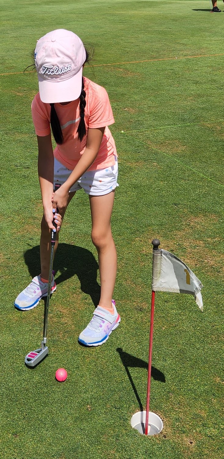 Riley Church-Bradley practices her putting at the recent Swan Lake Golf & Country Club junior golf camp.