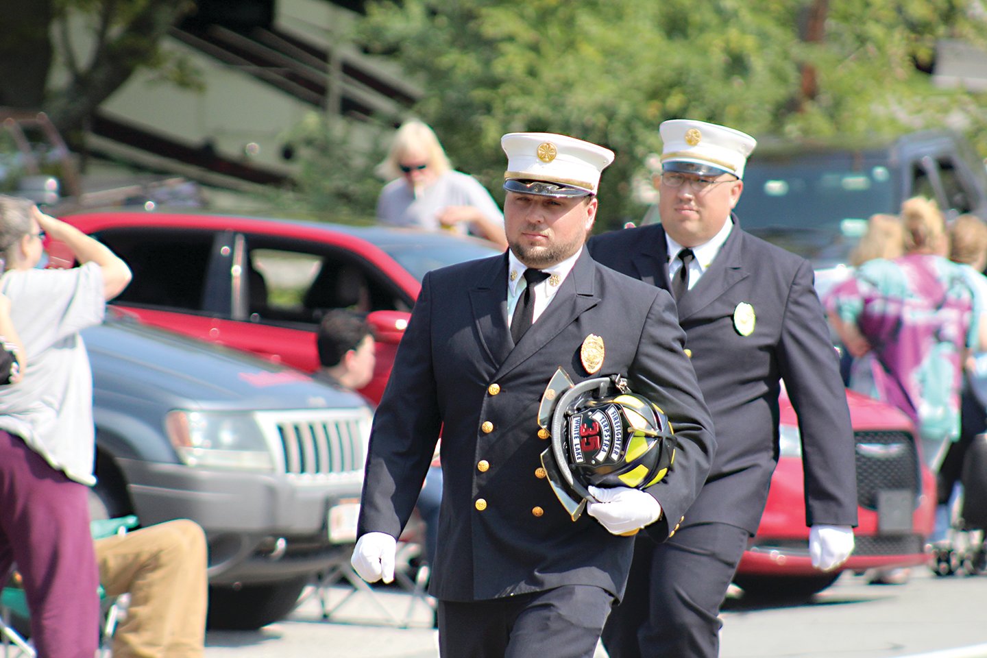 White Lake Fire Chief Joshua Cunningham carries the helmet of the late Aaron Terpstra, who passed away in February.  Marching behind Chief Cunningham is his brother and 1st Assistant Chief Shane Cunningham.
