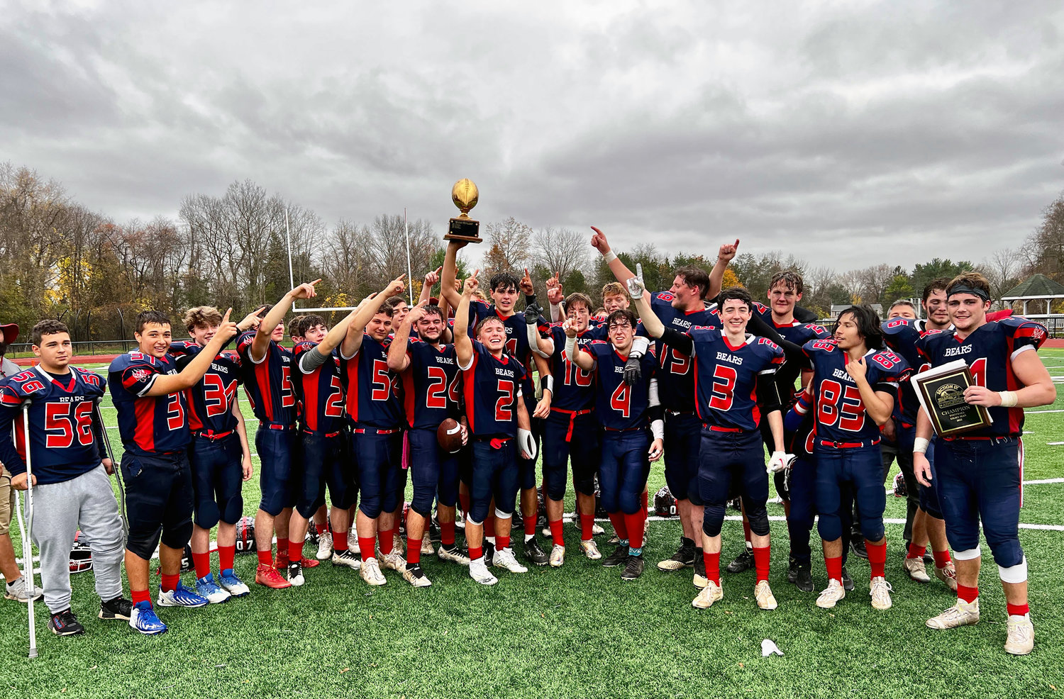 The victorious Bears hold the Fred Ahart trophy aloft in a moment of postgame exuberance.
