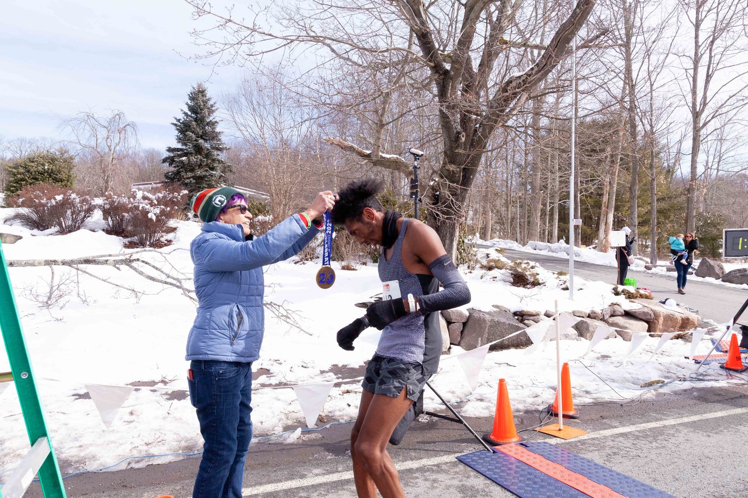 Myriam Loor, the race director, welcomes the Forestburgh resident Evan Waterton as he crosses the finish line in first place.