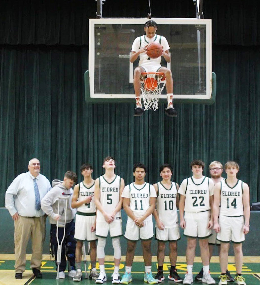 Coach Furler and the Yellowjackets pose in front of the basket while Trai Kaufmann looks down from above.