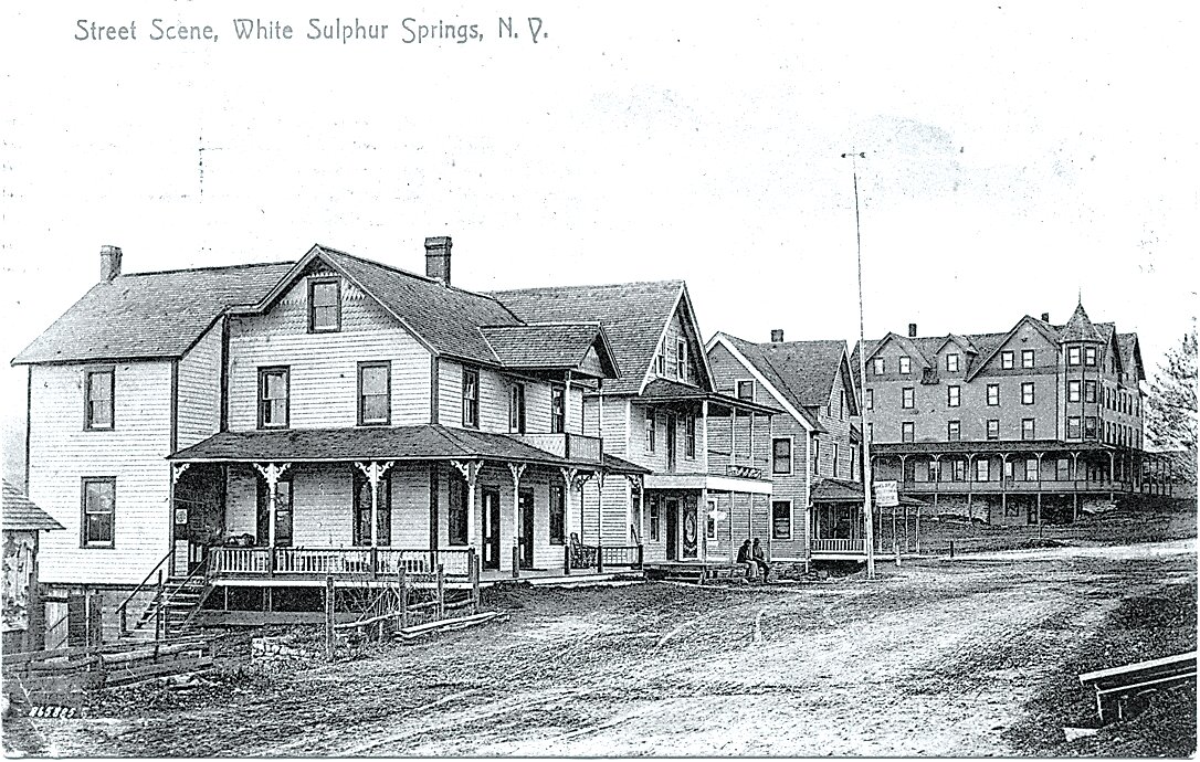 A busy corner at Briscoe Road:

After we published this photo in Glancing Back (March 7, 2023 issue), we heard from Katherine Calkin who grew up on Briscoe Road. She wrote that Eben Lawrence owned the Hotel Lawrence [far right], the Leona, the feed store and miniature golf across the street where the fire department is today. Said Katherine, “The first kindergarten class in White Sulphur Springs [was] housed upstairs in the firehouse. June Ellmauer started the year with us, but was replaced by Edith Paul when Mrs. Ellmauer became pregnant.” She also recalls Jack Eggler’s garage, Fishbein’s market which was only open in the summer, and the house which Jack Eggler lived in, which is on the pond. Does anyone have photos of the miniature golf or the early fire department that they would be willing to share? If so, call Ruth at (845) 887-5200 or email alookatyesteryear@gmail.com