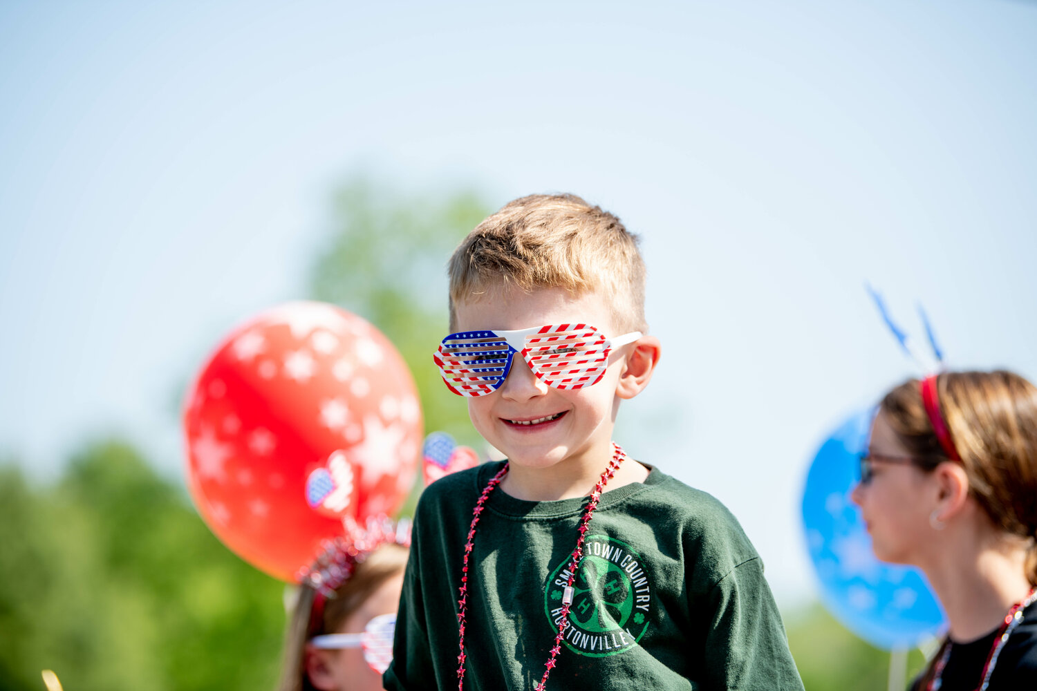 Left: Sawyer Haff grins from behind his patriotic shades on the Small Town Country 4H float.