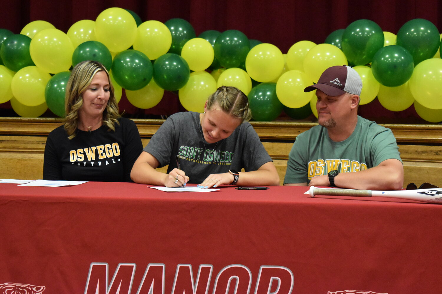 Mackenzie signs her letter of intent flanked by her parents Shyla and Aaron.