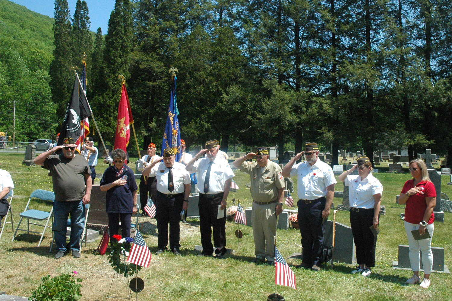 Members of Allan Milk Memorial VFW Post 7276 salute to the ceremonial bouquet after placing each item down one by one. From left to right, Mike Ristics (aka Bugman); Kathy Geosits; Bruce Pesci; Frank Geosits; Art Flynn; Chris Roman; Lauren Roman; and Amber Sullivan, Auxiliary President.