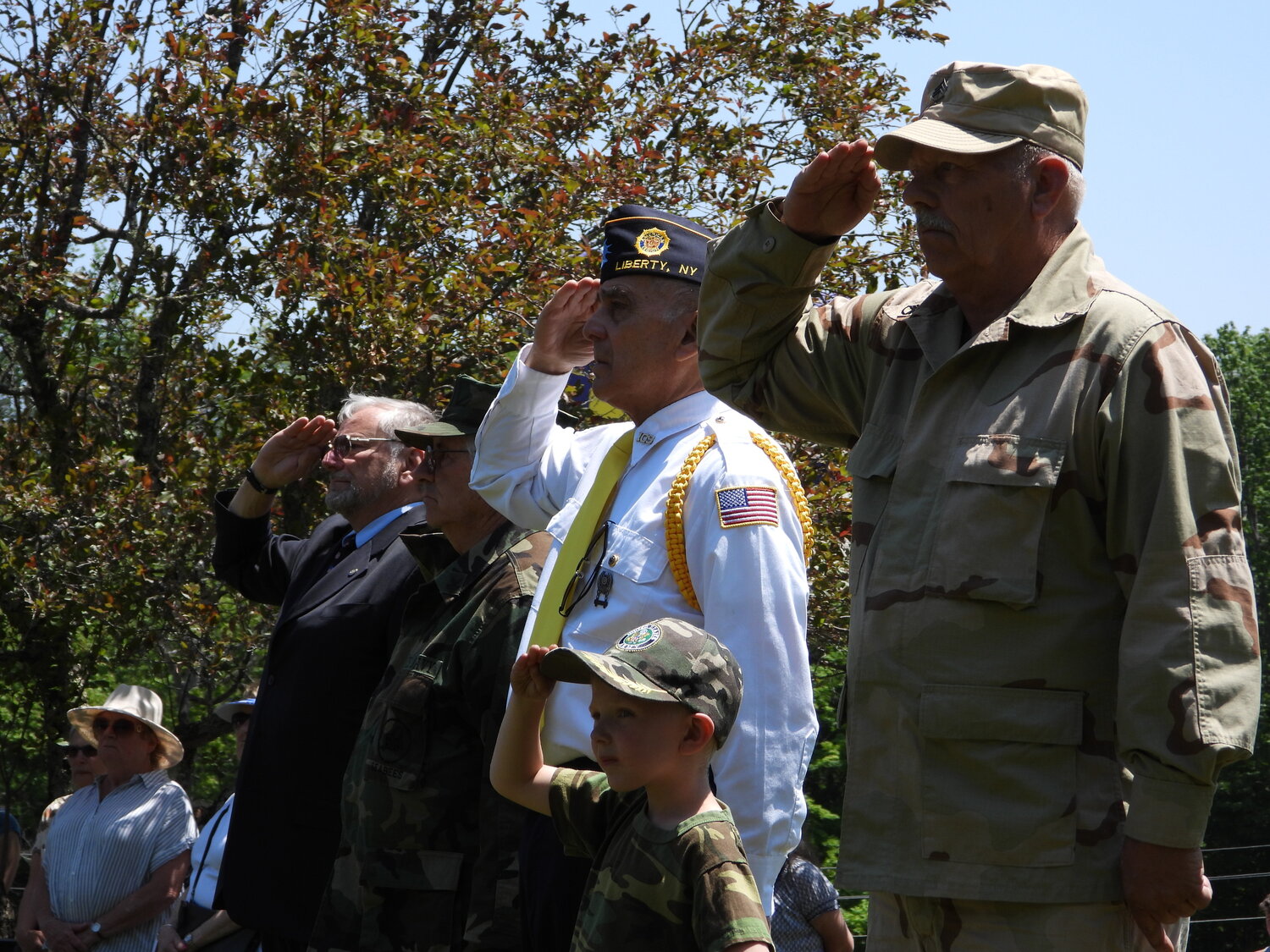 Saluting the honored fallen are, in front, veteran Chris Sutowski and his son, Richard, alongside Rudy Santiago, Alan Wilenken, and Rev. Walter Haff.