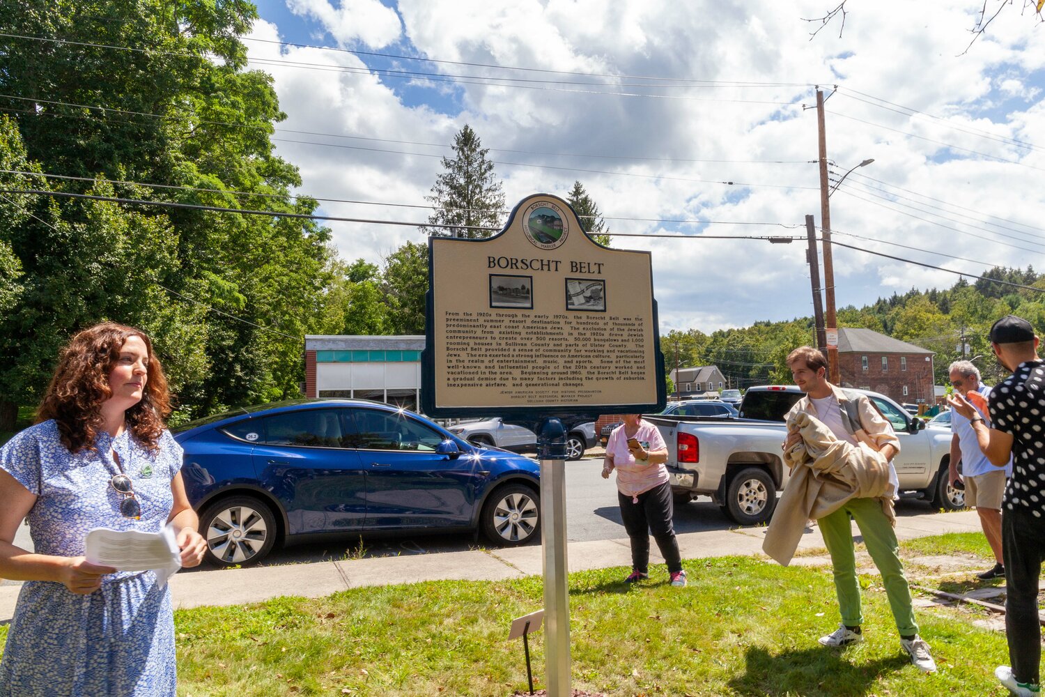 Marisa Scheinfeld, left, and Isaac Jeffreys jointly reveal the Mountaindale Borscht Belt Road Marker. This marker stands as a commemoration and educational symbol, shedding light on the historical significance of the Borscht Belt Era within the context of Mountaindale’s history.