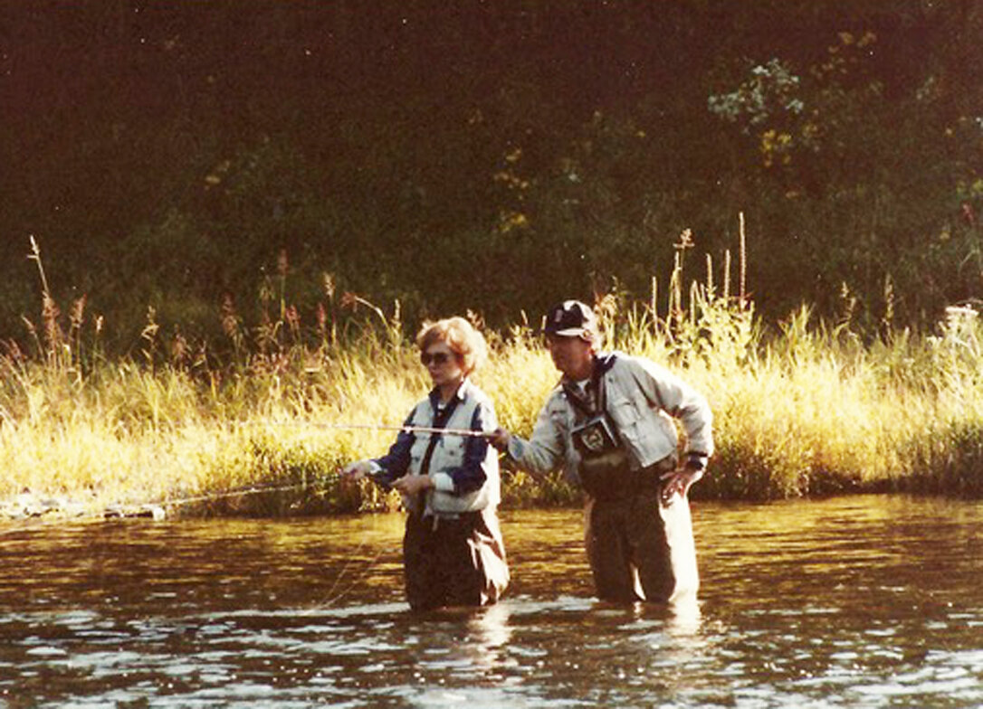 Above: Ed Van Put points out a rising fish to Rosalynn, left, while fly fishing the Delaware River while on a trip in 1984.
