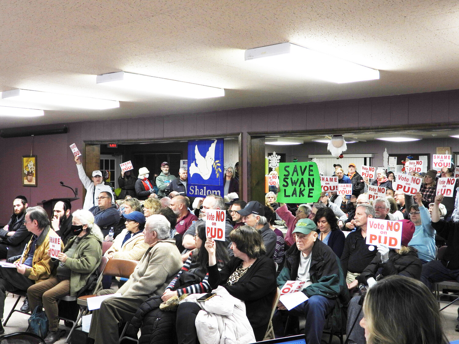Dozens of concerned Liberty residents held up signs and displayed their disapproval for the proposed Lake Hills Estates Planned Use Development (PUD), which has since been denied by the Town Board by 3-2 vote in the wake of a three-month moratorium on PUD’s.