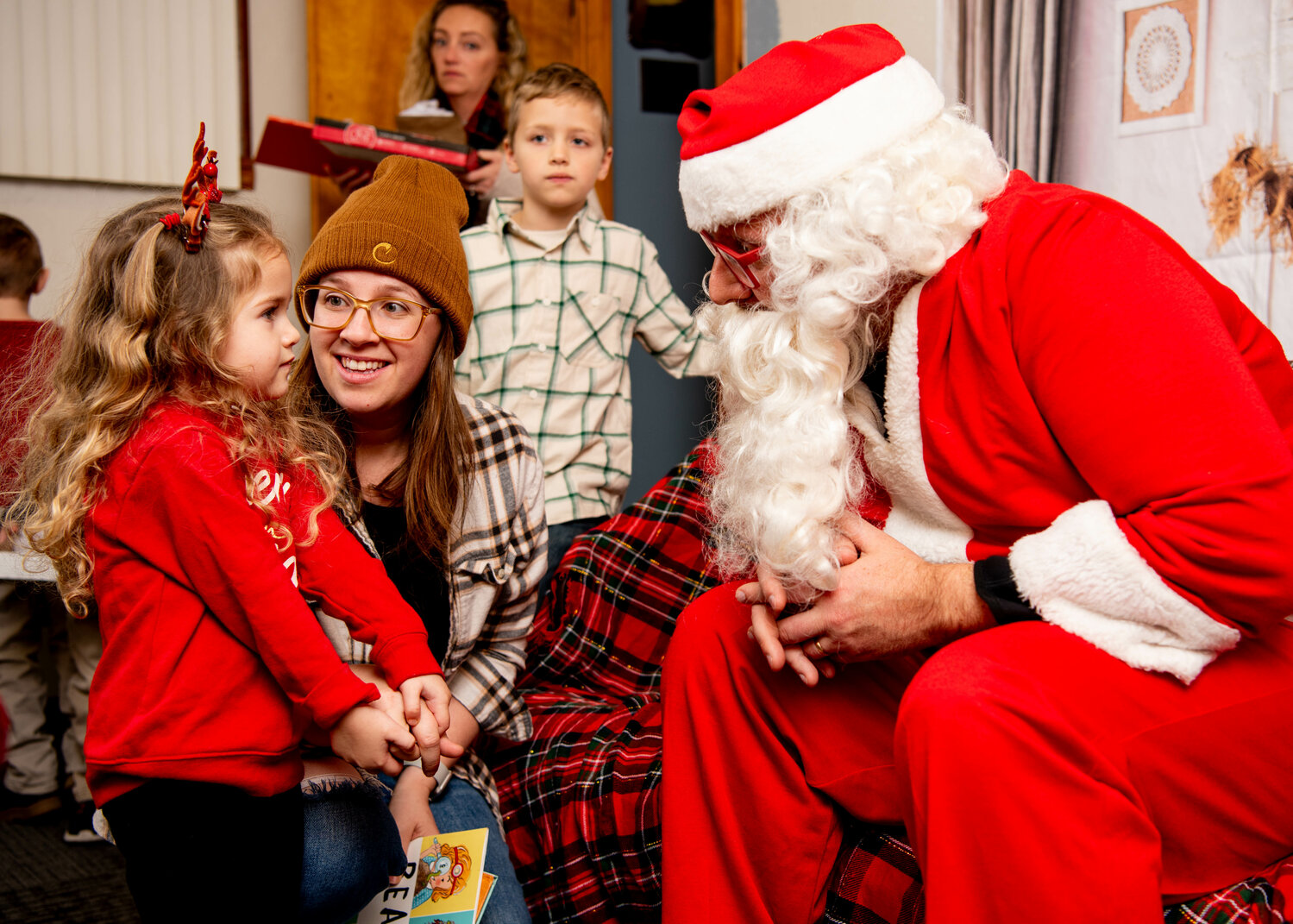 Above: Libby Percoco has a chat with Santa while mom April looks on.