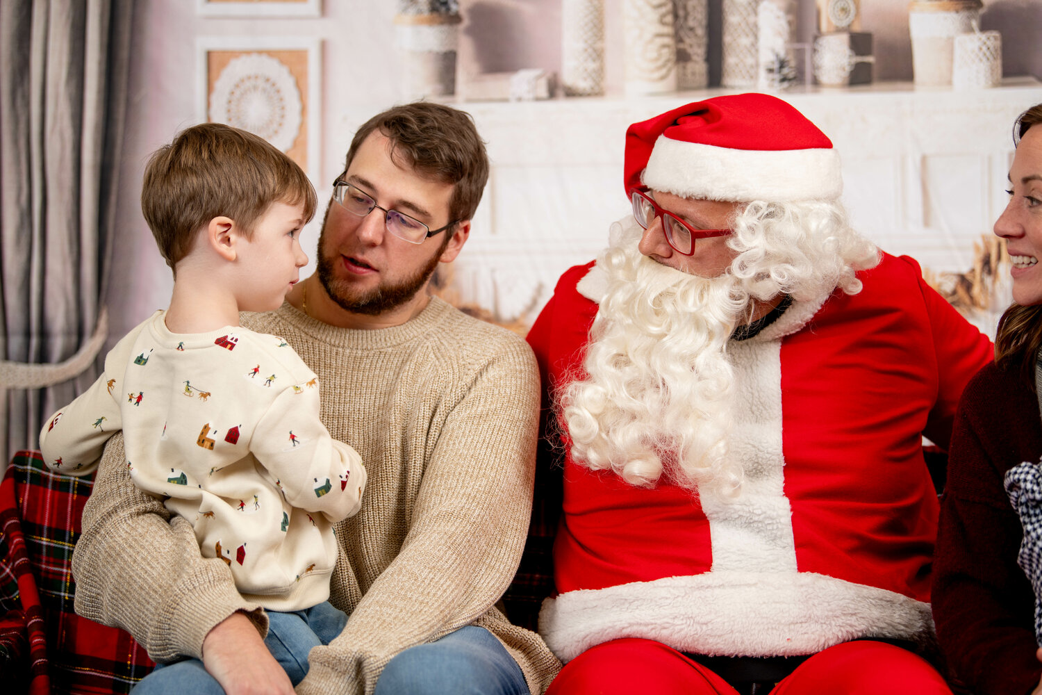 Right: Austin Brandt tells Santa what he wants for Christmas while sitting on dad TJ’s lap.
