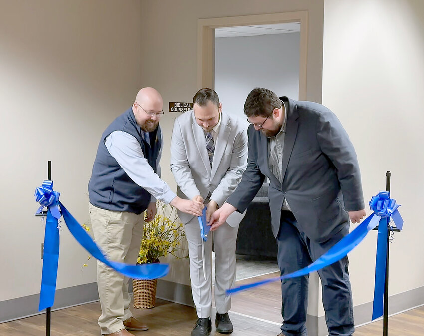 : On Monday, May 12, First Baptist Church Pastor Dr. Jeremiah Greever, center, Pastor Andrew Forshee, and Pastor Andrew Bryant cut the ribbon for the new Biblical Counseling Center Grand Opening.