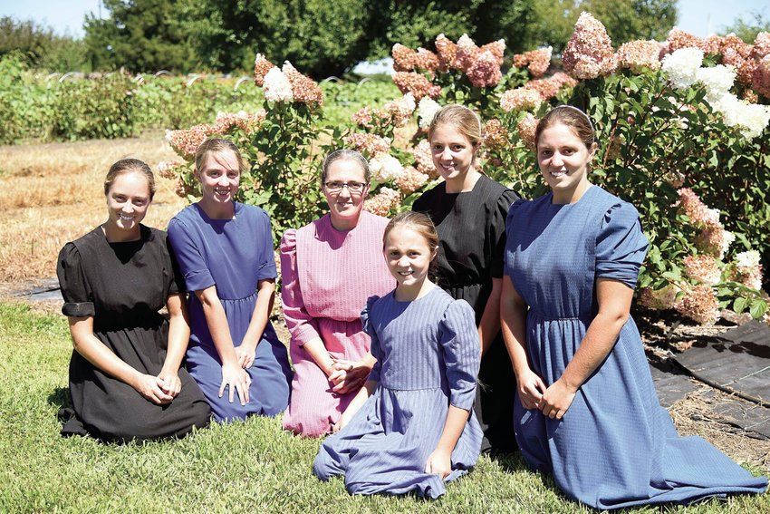 Ann Miller, center, poses with her five daughters Monday at the family&rsquo;s property, Twisted Cedar Farm, near Houstonia. The farm is owned by Ann and her husband, Joseph, Miller. From left are Kayla, 23, Jenna, 15, Ann, Lindsey, 10, Kyra, 17 and Kendra, 20. The Millers are new vendors with the Sedalia Area Farmers&rsquo; Market.