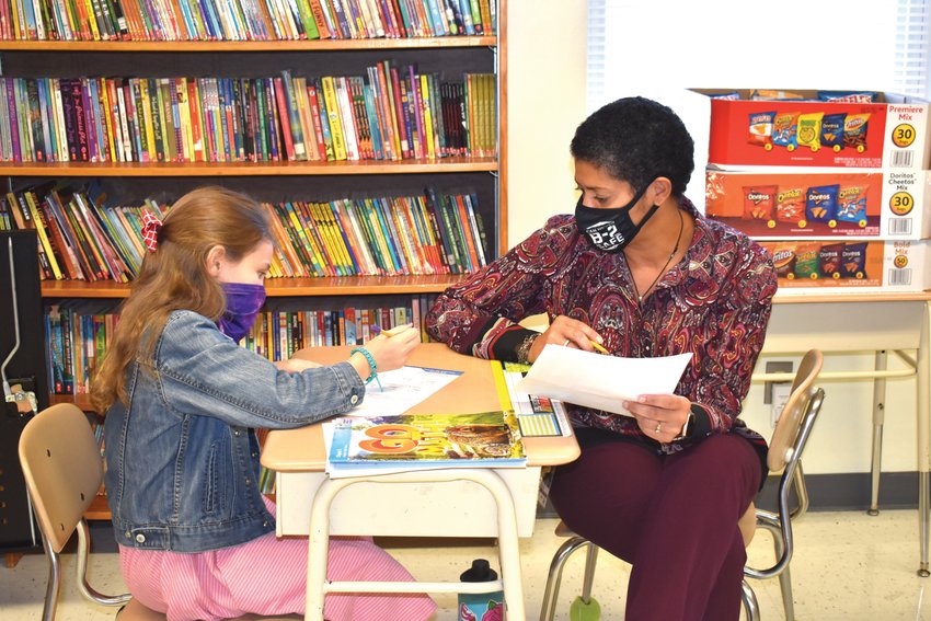 Green Ridge fourth grade teacher Kelly Davis works with student Kaelyn Weisenburger Thursday morning in her classroom. Green Ridge has adopted a four-day school week, which has proven to be beneficial this year in the midst of the COVID-19 pandemic.