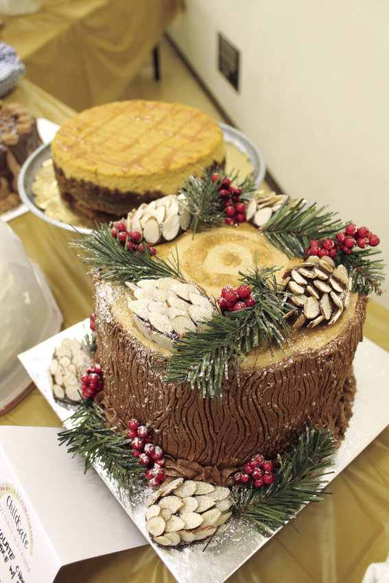 A chocolate chocolate chip cake with edible pinecones made by Megan Evans sits on the live auction table for the annual Child Safe Celebrity Dessert Auction in 2018. Behind it is a pumpkin cheesecake made by Sarah Nail.