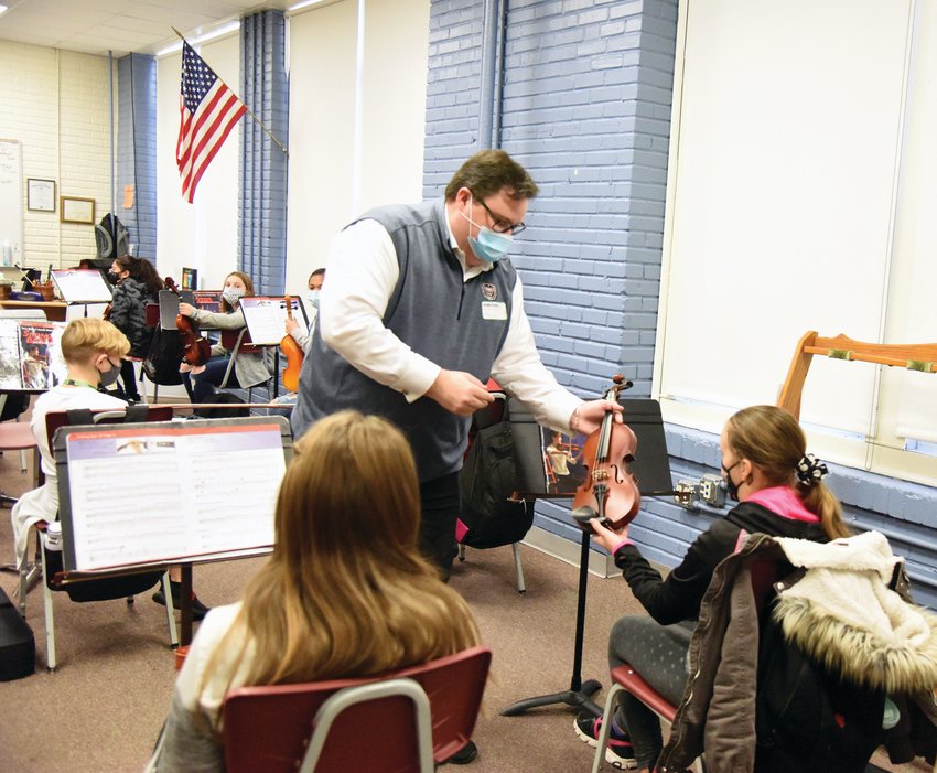 Dr. Christopher Kelts, the director of orchestral studies and associate professor of music at Missouri State University, tunes an instrument for a Smith-Cotton Junior High student Thursday morning. Kelts is conducting two days of instruction for Sedalia School District 200 string students this week. Due to COVID-19, the event sponsored by the Sedalia Symphony Society will take the place of the annual StringFest hosted at SCJH. A mini online concert will be available at noon Saturday.