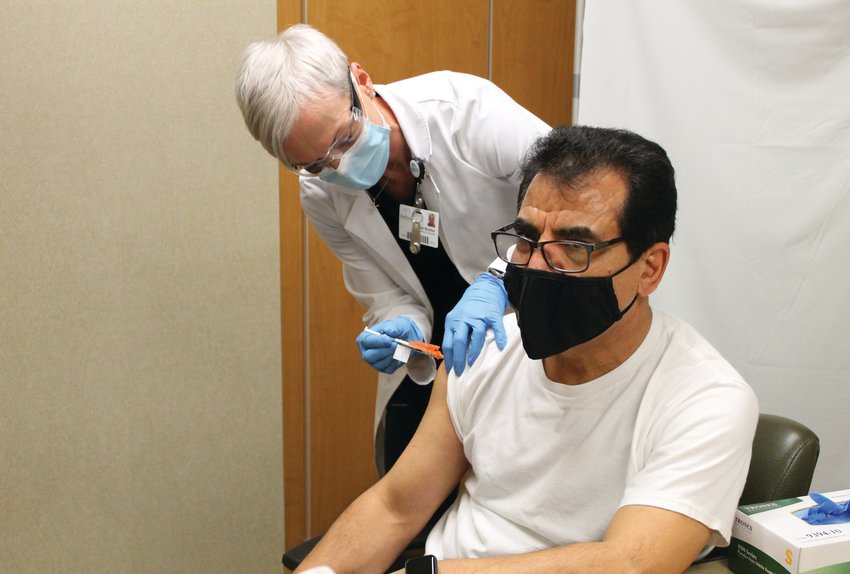 Sarah Wuellner, RN, of the Infection Control Department at Bothwell Regional Health Center, gives Dr. Assad Shaffiey, of Bothwell TLC Pediatrics, one of the first COVID-19 vaccines in Sedalia on Friday morning.