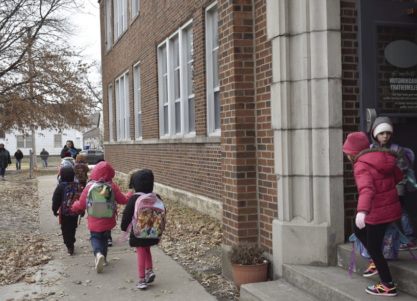 Kindergarten students from Washington Elementary brave the cold and light snow flurries Tuesday, Jan. 29, 2019, as classes are dismissed for the day.
