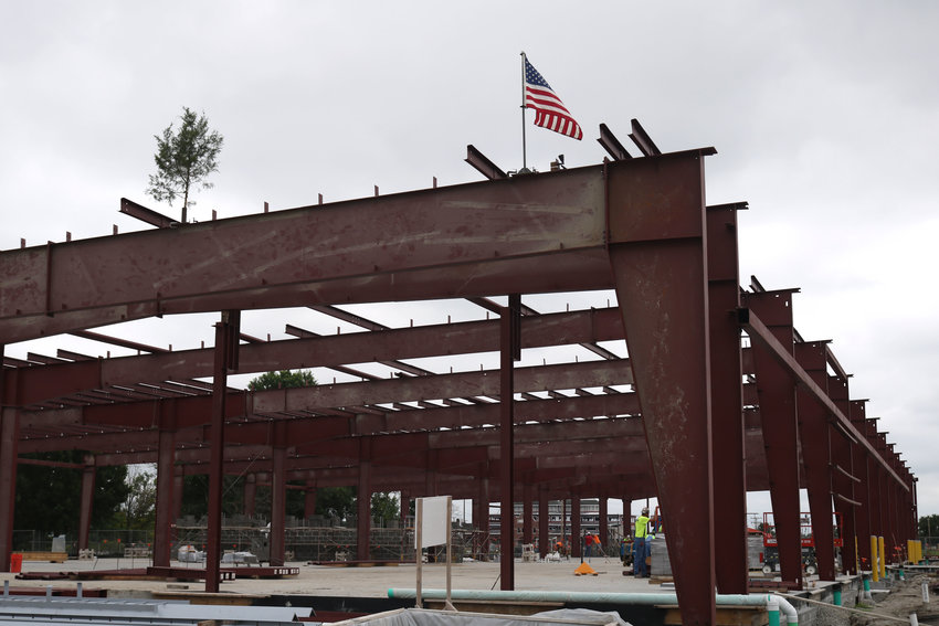 A small tree and an American flag are placed on top of the steel structure that will eventually be the Olen Howard Workforce Innovation Center during a top off ceremony Thursday morning at State Fair Community College. According to SFCC Director of Building Management Justin O&rsquo;Neal, a top off ceremony occurs after the last main steel structure for a building goes up.