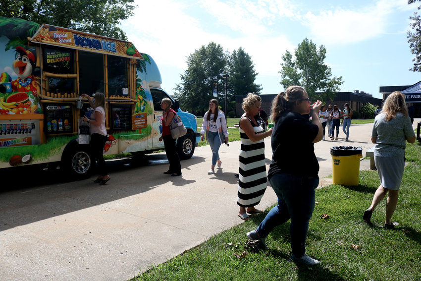 Near the front entrance of State Fair Community College, students and staff gather around the Kona Ice truck for free snow cones on Monday for the first day of the fall semester. The truck was part of student activities for the first day of school, with more activities scheduled for the next two weeks.