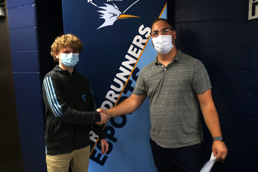 Carter &ldquo;Peachy&rdquo; Woods, left, and State Fair Community College esports coach Jacob Coleman shake hands after Woods signed his contract with the esports team on the first day of practice Sept. 14. Woods was the first player to sign up for the esports team, which begins its first year as a team for SFCC.