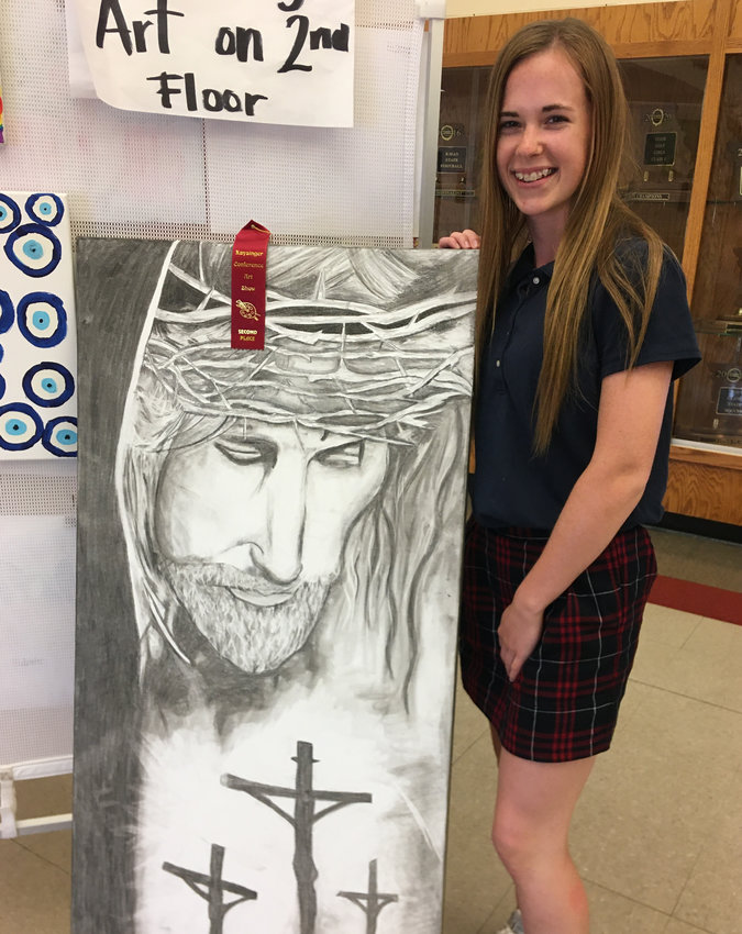 Junior Abby Arnold stands with &ldquo;My Savior,&rdquo; her entry in the first-ever Sacred Heart Art Show Thursday.