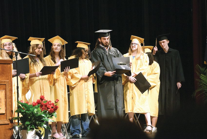 After receiving their high school diplomas Friday evening, Whittier graduates, including John Isaac Bayless, center, look over their certificates. This year was the 25th and largest graduating class for Whittier High School. Ceremonies took place at the Smith-Cotton High School Heckart Performing Arts Center.