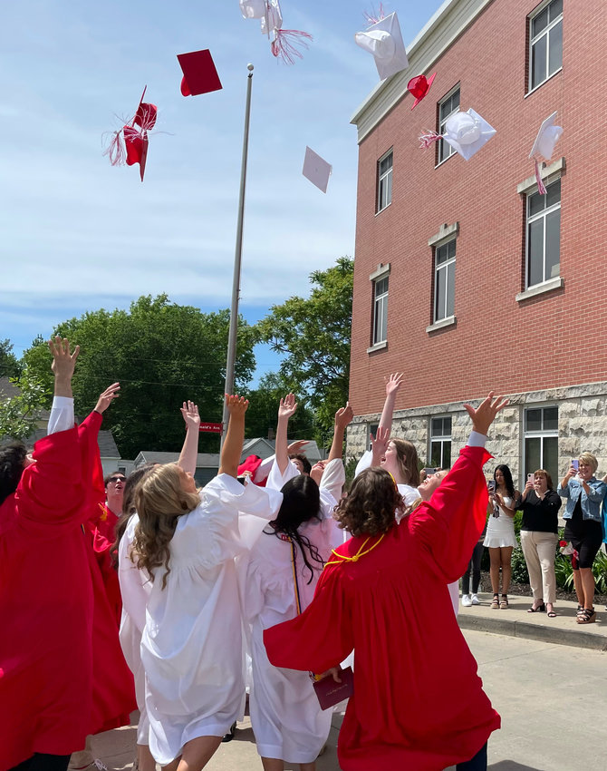 Sacred Heart 2022 graduates fling their caps in the air after Sunday&rsquo;s ceremony at Sacred Heart School.