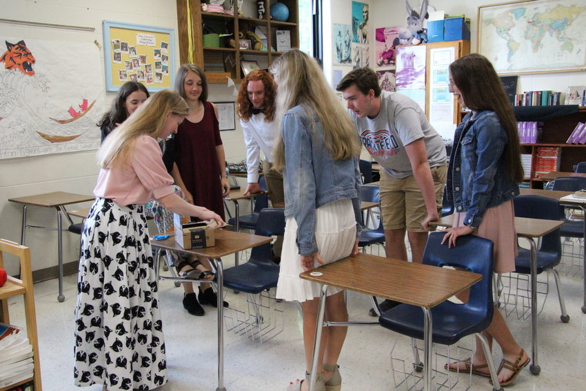 Smithton Introduction to Literature juniors and seniors open the package that holds the book they wrote and published throughout their school year on Wednesday morning.