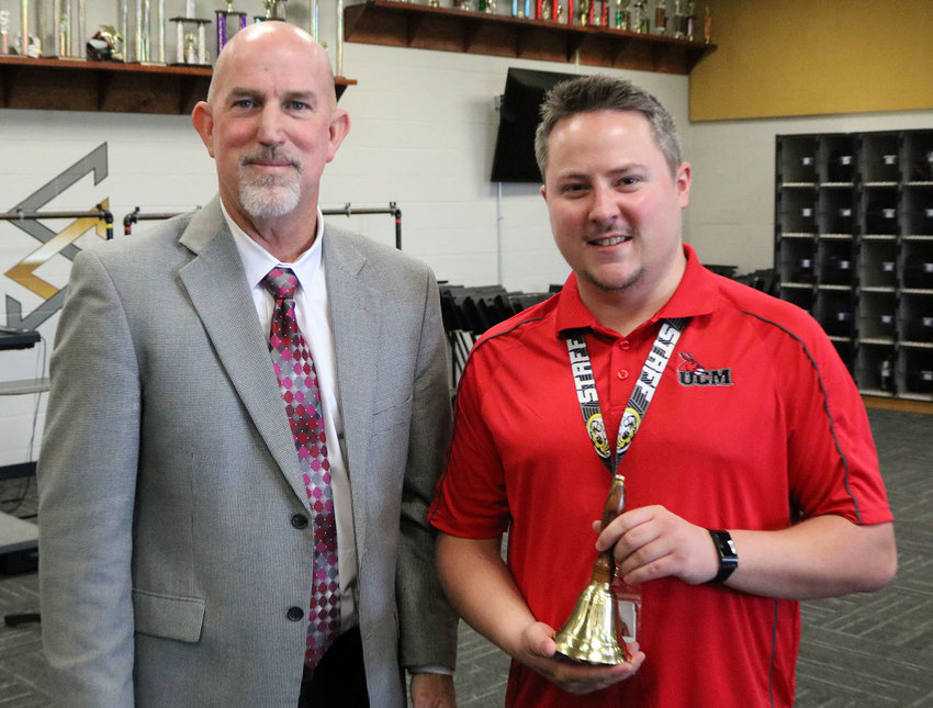 Sedalia School District 200 Superintendent Steve Triplett, left, presents instrumental music teacher Andrew Fischer with the Superintendents&rsquo; Bell Ringer Award on Tuesday, May 17, at Smith-Cotton High School.