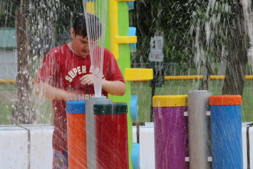 Yale Foster, son of Sedalia Ward 4 Councilwoman Rhiannon Foster, plays the bongos in the new Hubbard Park splash pad on Thursday morning. Open hours for the free aquatic attraction are 10 a.m. to 8 p.m.
