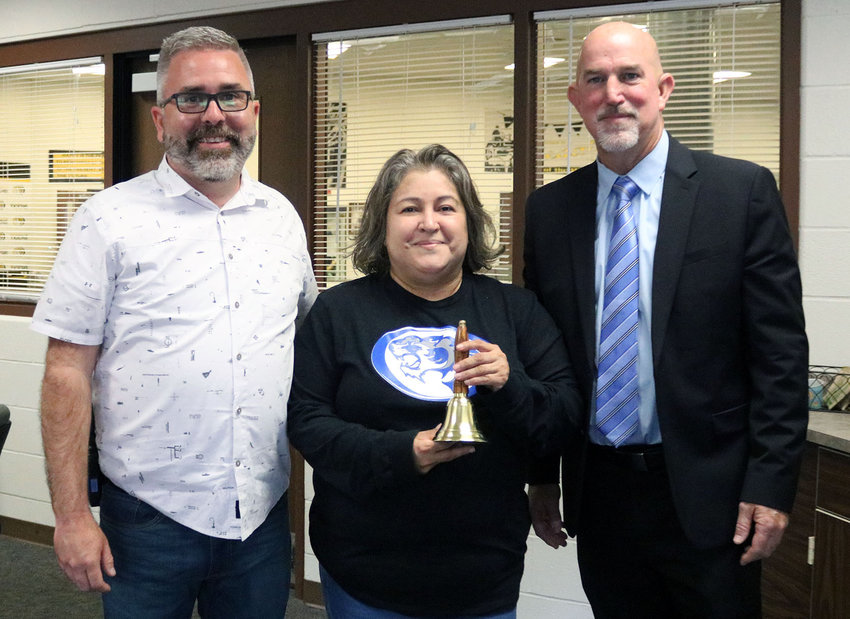 Sedalia School District 200 Superintendent Steve Triplett, right, presents bilingual interpreter Lesther &ldquo;Tita&rdquo; Reedy with the Superintendent&rsquo;s Bell Ringer Award on Friday, May 27, at Smith-Cotton High School. At left is S-C High Principal Wade Norton.