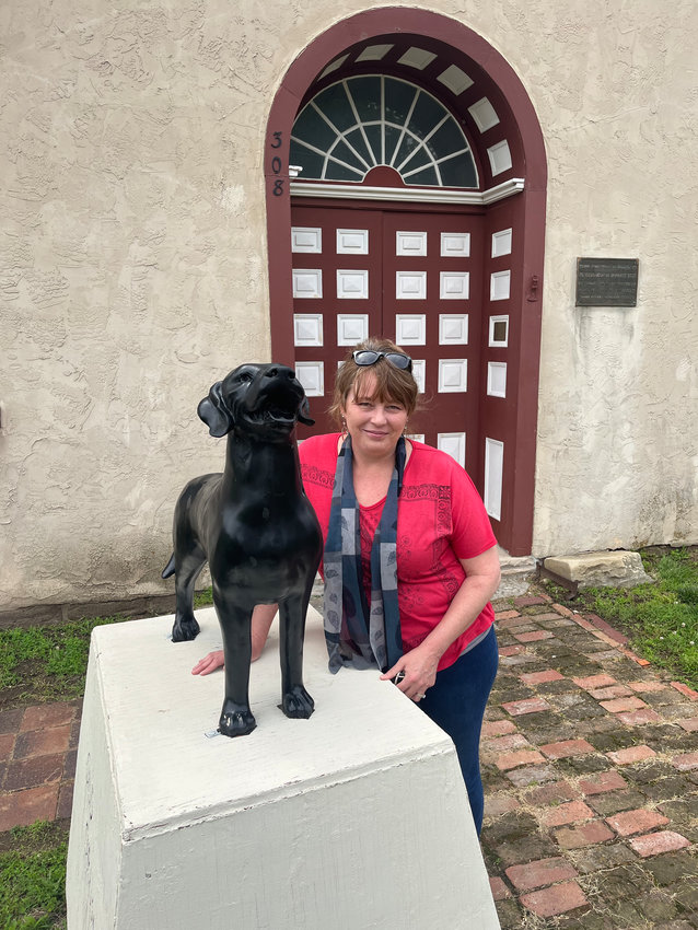Joyce Dorrell poses by the Old Drum Memorial in front of the historic Johnson County courthouse on Wednesday afternoon. The memorial will be on display at Old Drum Day on Saturday, and the courthouse will be used for entertainment.