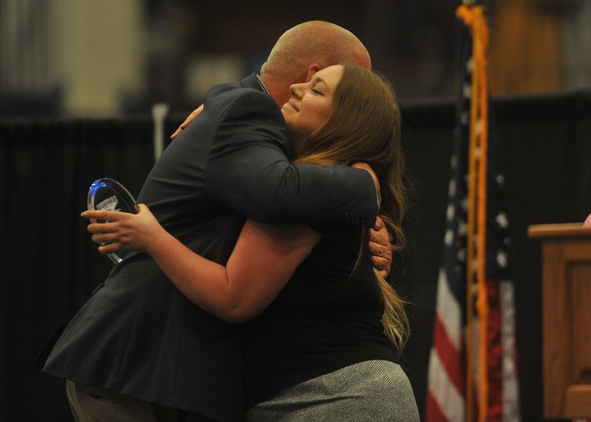 Sara Perkins, the daughter of late State Fair Community College play-by-play announcer Denny Perkins, gets a hug following her speech from athletic director Darren Pannier at the Roadrunners Athletic Hall of Fame Ceremony on May 12 that inducted both Perkins and former hoops standout Kenny Chery.