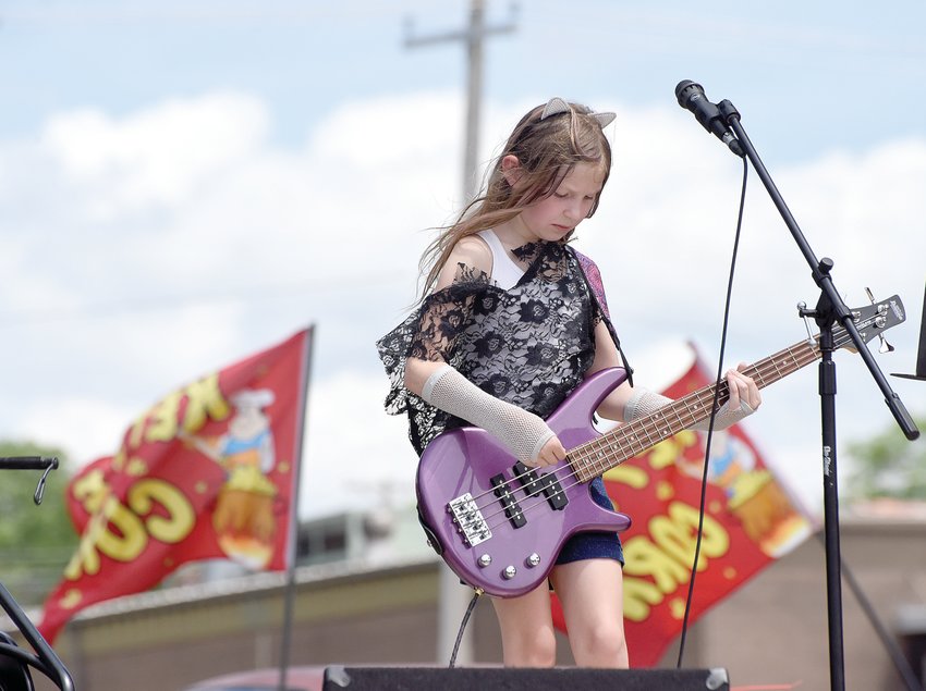 Rachel Rowland, 9, plays her purple bass with her group 30 Seconds Til Famous on Saturday at the Making the Band Concert in downtown Sedalia. The Making the Band concert is an annual event that showcases the talents of local youth under the instruction of Justin Lawson.