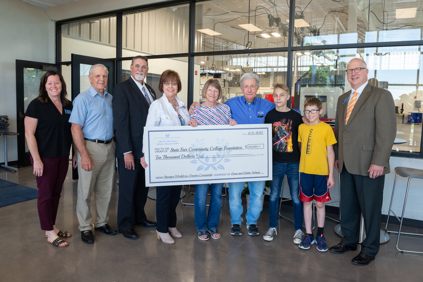 Gary and Debbie Noland with their grandsons present a $10,000 gift to support the State Fair Community College Foundation&rsquo;s capital campaign for the Olen Howard Workforce Innovation Center. The presentation took place on June 9 in front of the precision machining lab in the new center. From left, Mary Treuner, SFCC Foundation executive director; Steve Ellebracht, SFCC Foundation vice president and campaign co-chair; Dr. Brent Bates, SFCC vice president for Educational and Student Support Services; Dr. Joanna Anderson, SFCC president; the Nolands and grandsons Patrick and Zachary Childs; and Joe Fischer, SFCC Foundation president and campaign co-chair.