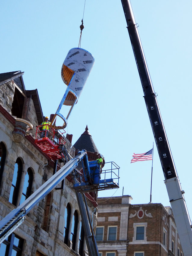 Construction workers guide the base of a new turret onto the roof of the Trust Building on Tuesday, June 28 in downtown Sedalia. CSC Construction owns the historic structure and has been working for several years to restore it for modern use.