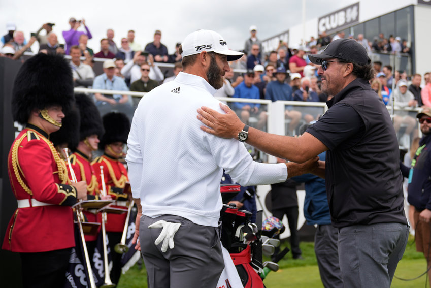 Dustin Johnson of the United States, left, and Phil Mickelson of the United States greet each other on the first tee during the first round of the inaugural LIV Golf Invitational at the Centurion Club in St. Albans, England, Thursday, June 9, 2022. (AP Photo/Alastair Grant)