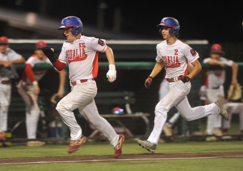 Josh Hagle (2) strides behind Hayden Zeiler before both slide into home plate and score in the third inning of Sedalia Post 642 AUX's game against Lee's Summit Post 189 Wednesday evening.