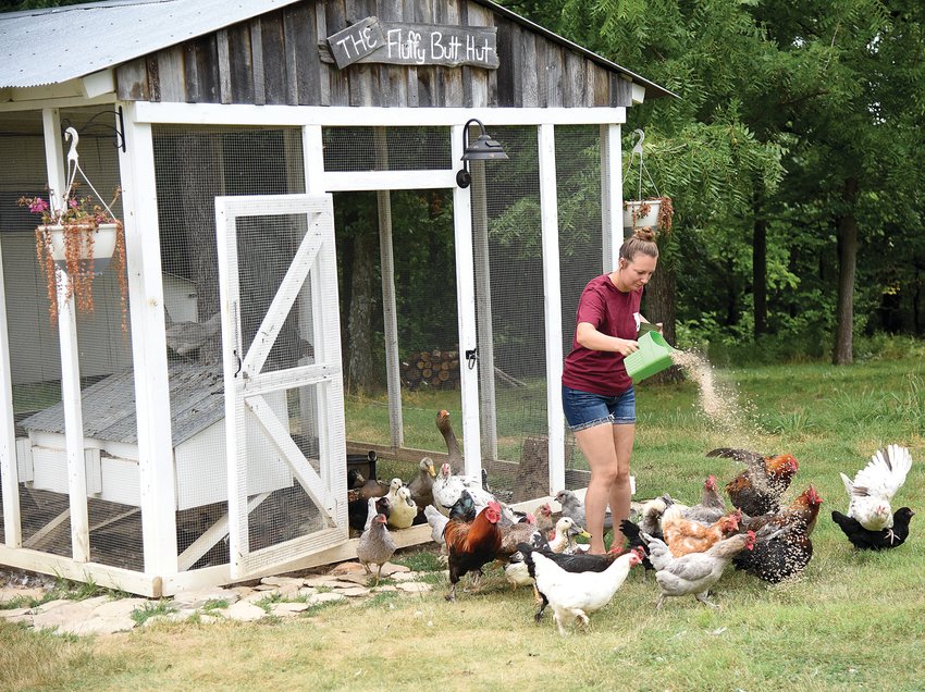 Marlee Dodson feeds her chickens and ducks Thursday morning at Mulberry Bottoms Farm in northern Pettis County. Dodson owns the farm with her husband, Greg Dodson, and is at the Sedalia Area Farmers&rsquo; Market each Tuesday.