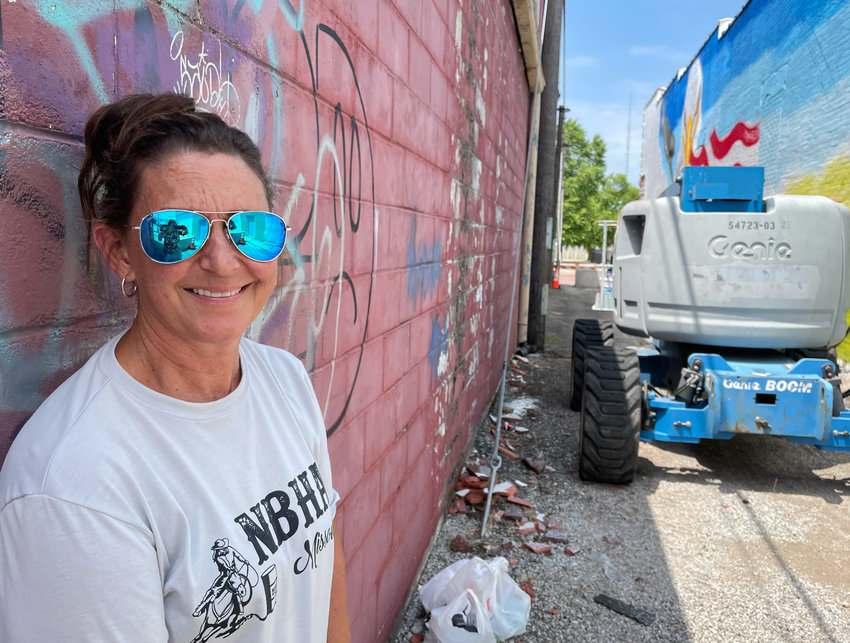 Muralist Stefanie Aziere-Sattler is seen in the alley at 209 S. Ohio Ave. The graffiti-painted alley is being revitalized with a mural, decorative lighting, and asphalt paving.