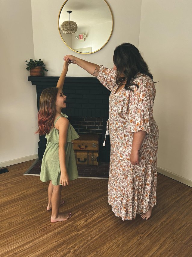 Krista Metcalf, owner of Wild Jade Boutique, stands with her daughter inside the store. The inspiration behind the store's name comes from her daughter, whose middle name is Jade and is her wild child.