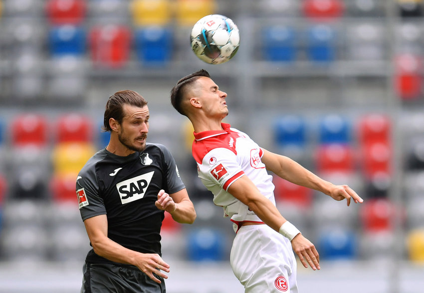 Dusseldorf's Erik Thommy and Hoffenheim's Havard Nordtveit, left, vie for the ball during the German Bundesliga soccer match between Fortuna Duesseldorf and Hoffenheim, in Duesseldorf, Germany, Saturday, June 6, 2020. Because of the coronavirus outbreak all soccer matches of the German Bundesliga take place without spectators. (Marius Becker/Pool Photo via AP)