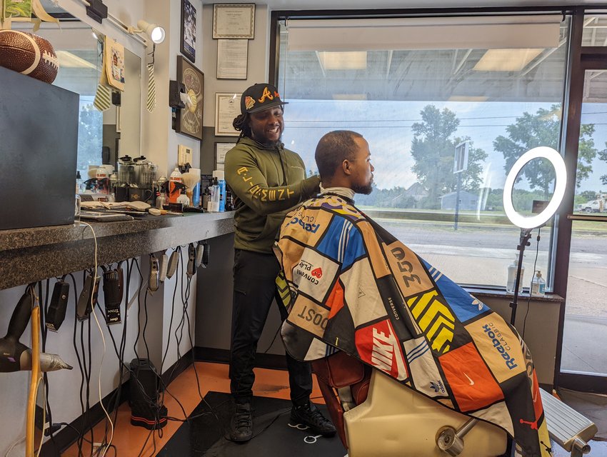 Willie Taylor, owner and barber of All-Starz Barbershop, cuts the hair of a patron at the Knob Noster location.