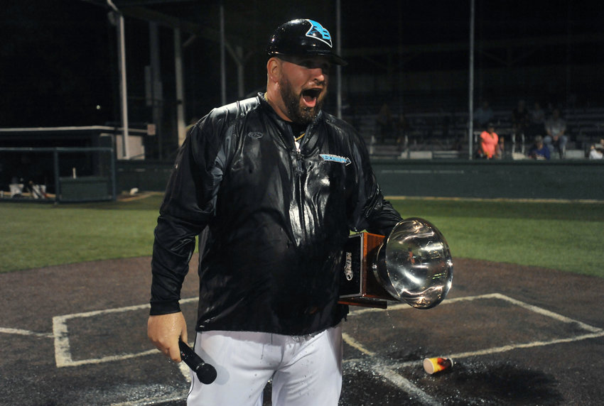 Bombers head coach Craig McAndrews holds the 2018 MINK League Championship trophy after players bathed him in the celebration following the title game.