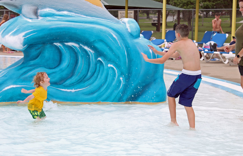 Jackson Moody, 3, left, splashes his cousin, 9-year-old Hunter Cornine, during an afternoon of swimming on Saturday at Centennial Pool. Saturday marked Centennial Pool&rsquo;s 50th birthday, which included 50-cent admission all day and 50-cent concession items, plus free T-shirts and cookies and raffles.