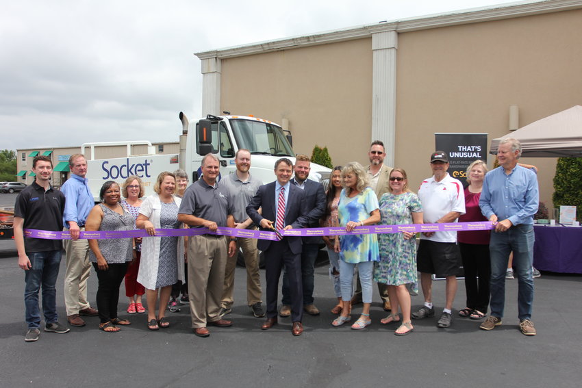 Socket President and CEO Carson Coffman cuts the ribbon during a ribbon cutting ceremony on Thursday, Aug. 4, at Arwood's Furniture.