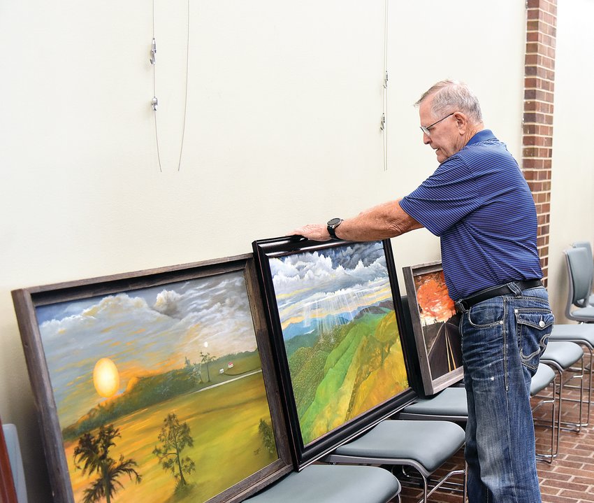 J. Ricker, a Sedalia Visual Art Association member, arranges his paintings Thursday morning at Sedalia City Hall. Ricker's show opens Friday, Sept. 16 and will run through Dec. 5.