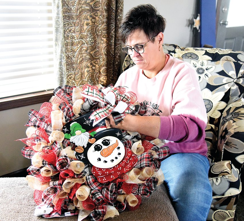 Gidget Funk, owner of The Funky Goat Paint Parties and Crafts, works on a wreath in her home Thursday morning in her rural home near Marshall Junction. Funk and her family raise cattle, goats, and bale hay on their farm. She began Funky Goat around a year ago.