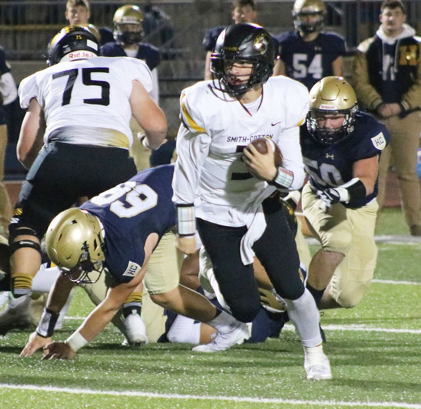 Smith-Cotton quarterback Lane Simmons (3) breaks free from Helias Catholic defenders for a 21-yard gain in the second quarter  of the Tigers' 45-21 loss to the Crusaders on Friday night at Ray Hentges Stadium in Jefferson City.